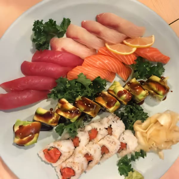 A platter of Sushi Bei's fresh sushi and sashimi, including tuna, salmon, and avocado rolls.