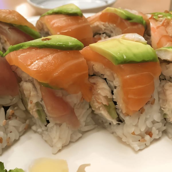 Close-up of Sushi Bei's salmon and avocado sushi rolls on a white plate.